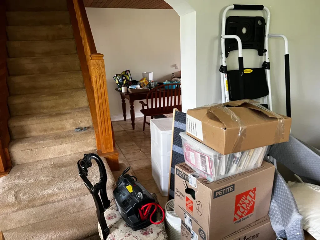 Professional movers loading boxes and furniture into a moving truck outside a Calgary home